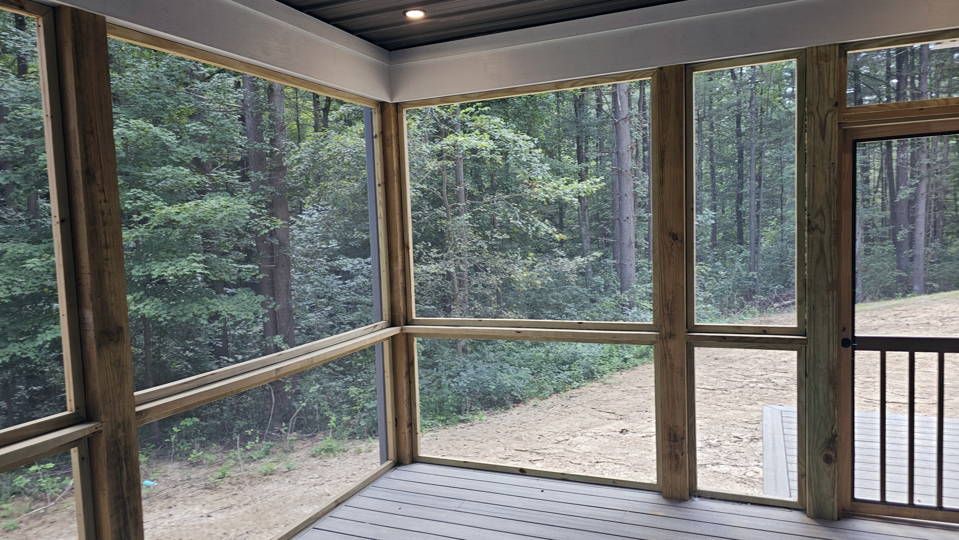 Screened porch overlooking the wooded setting at the Baird House